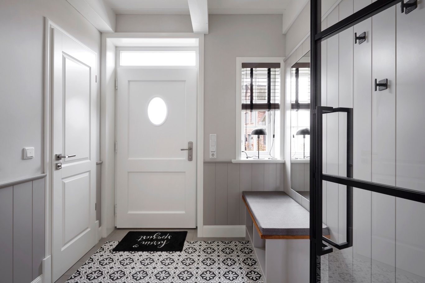 Eingangsbereich Moderner Eingangsbereich mit ovalem Fenster, Holzbank und Glaswand.