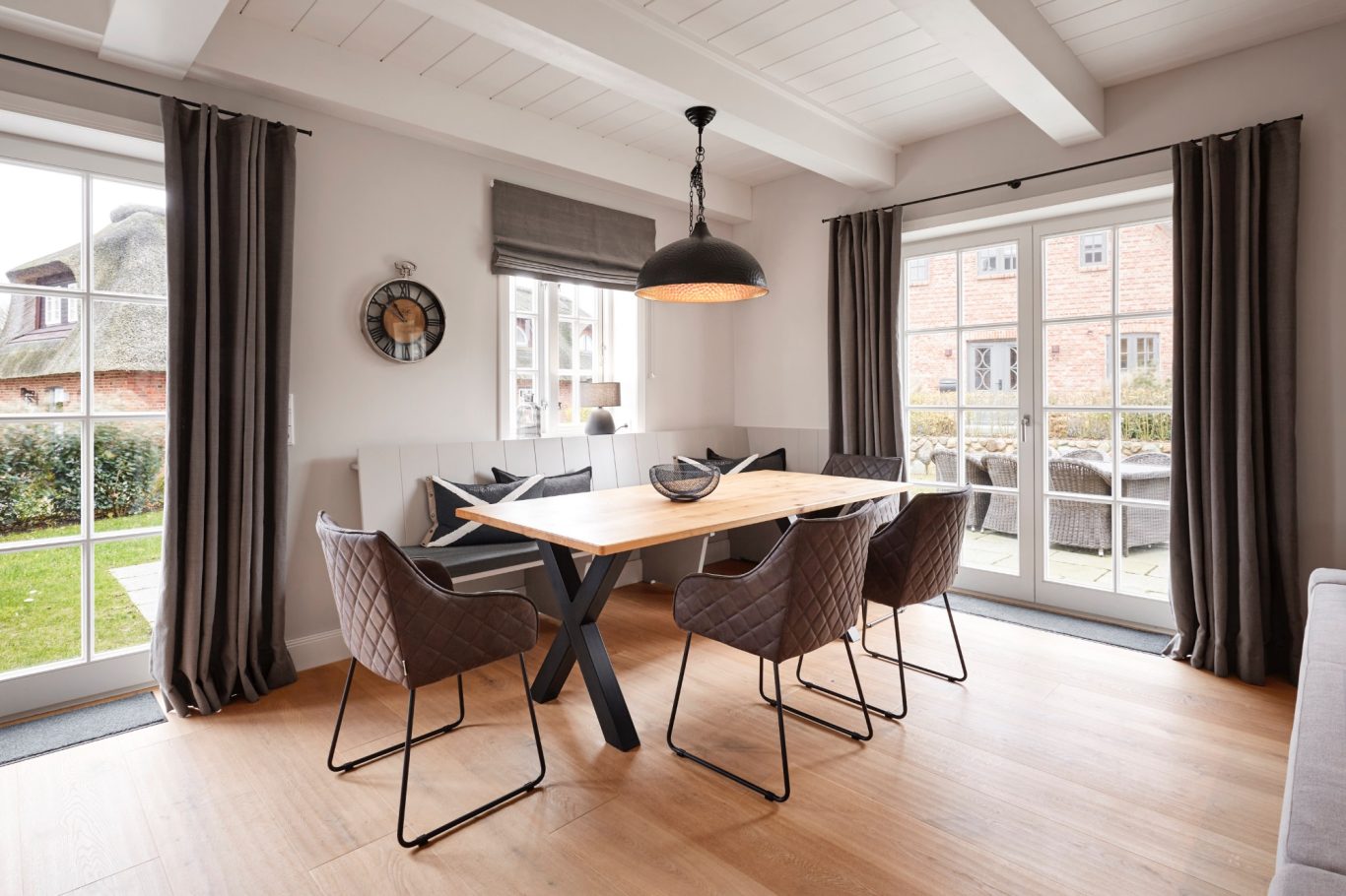 Essbereich Heller Essbereich mit Holzstisch, Stühlen, Pflanzen und einer großen Lampe.