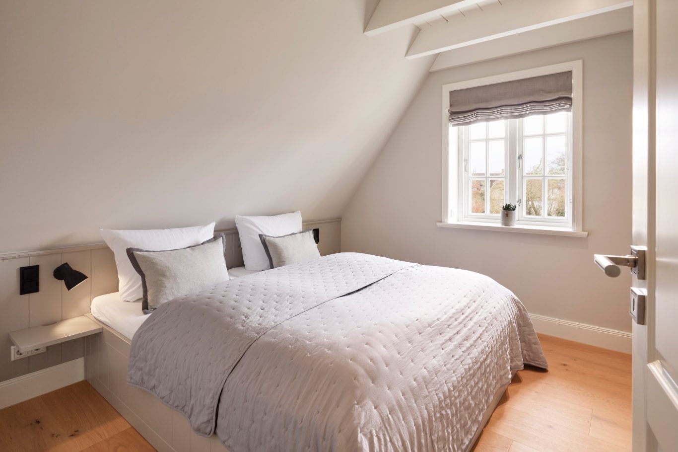 Zweites Schlafzimmer Helles Schlafzimmer mit Doppelbett, grauen Wänden und Fenster mit Rollläden.