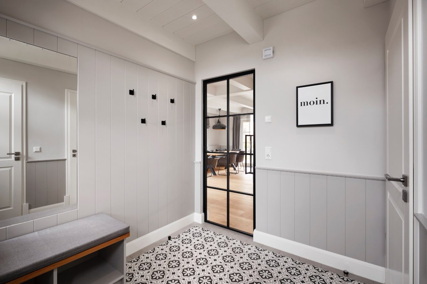 Zugang zum Wohnbereich Heller Eingangsbereich mit grauen Wänden, Fliesenboden und einer Glastür.