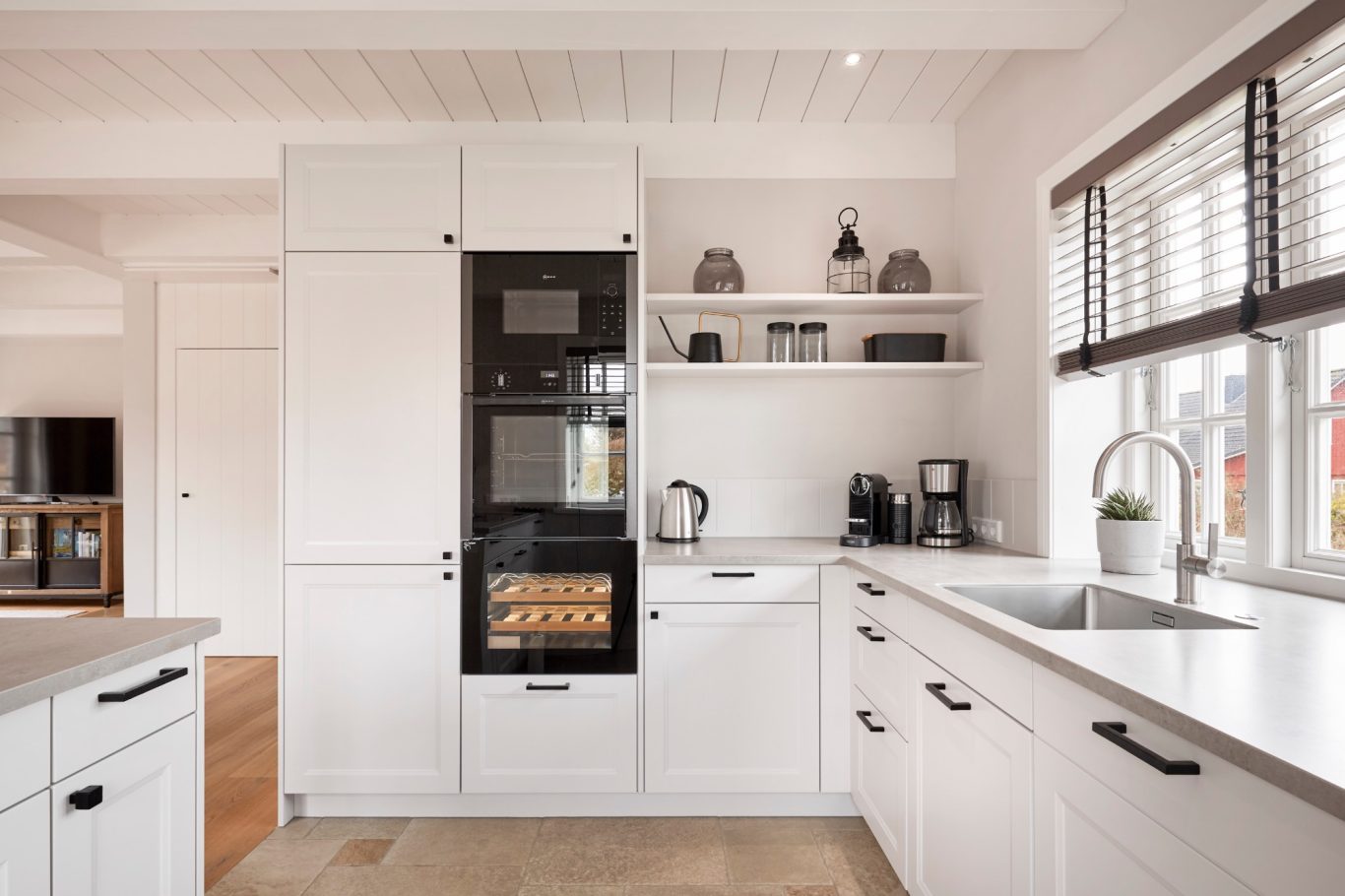 Küche Moderne Küche mit weißen Schränken, Backofen, Spüle und Küchenmaschinen.