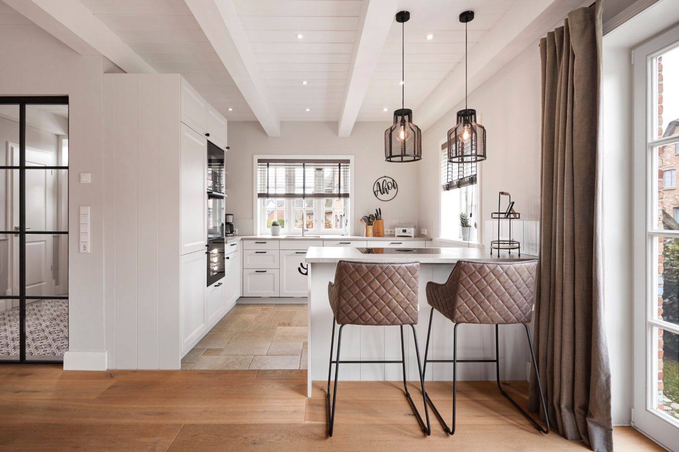 Erdgeschoss Moderne, helle Küche mit Barhockern, Holzfußboden und großen Fenstern.