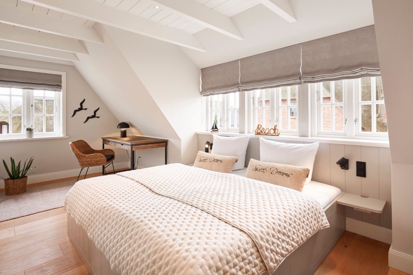 Master Bedroom Helles, minimalistisches Schlafzimmer mit Doppelbett und Schreibtisch unter schrägen Wänden.